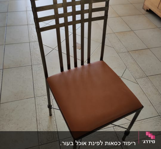 כיסא עם ריפוד עור חום על רצפה מרוצפת